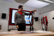 Ein Trainer demonstriert die Handhabung eines ABS Comfort Auffanggurts in einem Schulungsraum.